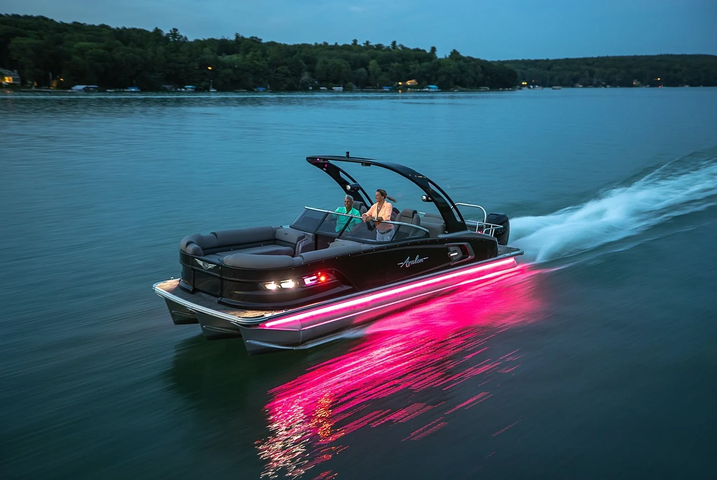 Avalon pontoon with purple LED underglow cruising at sunset